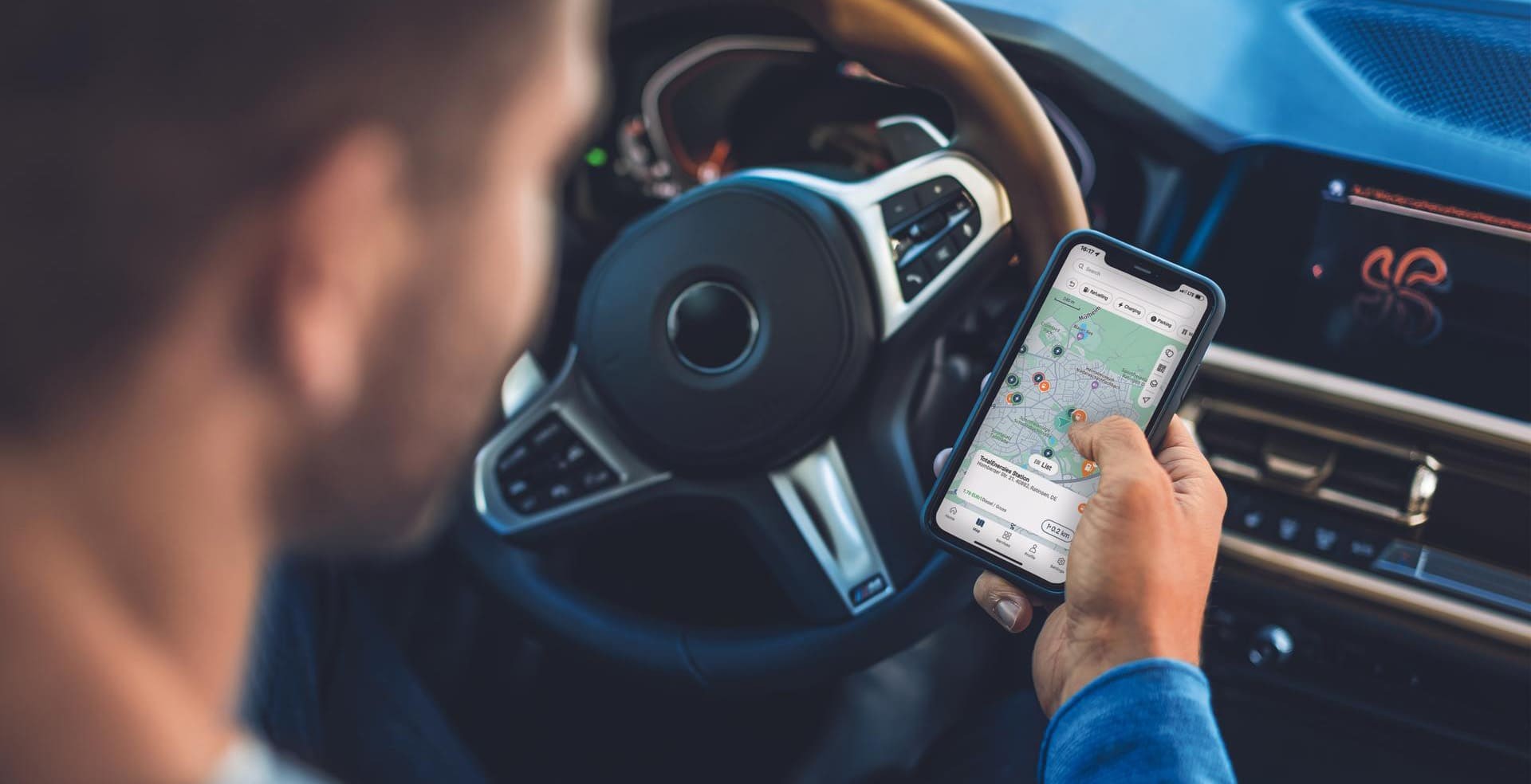 person scrolling hismobile phone while sitting in his car