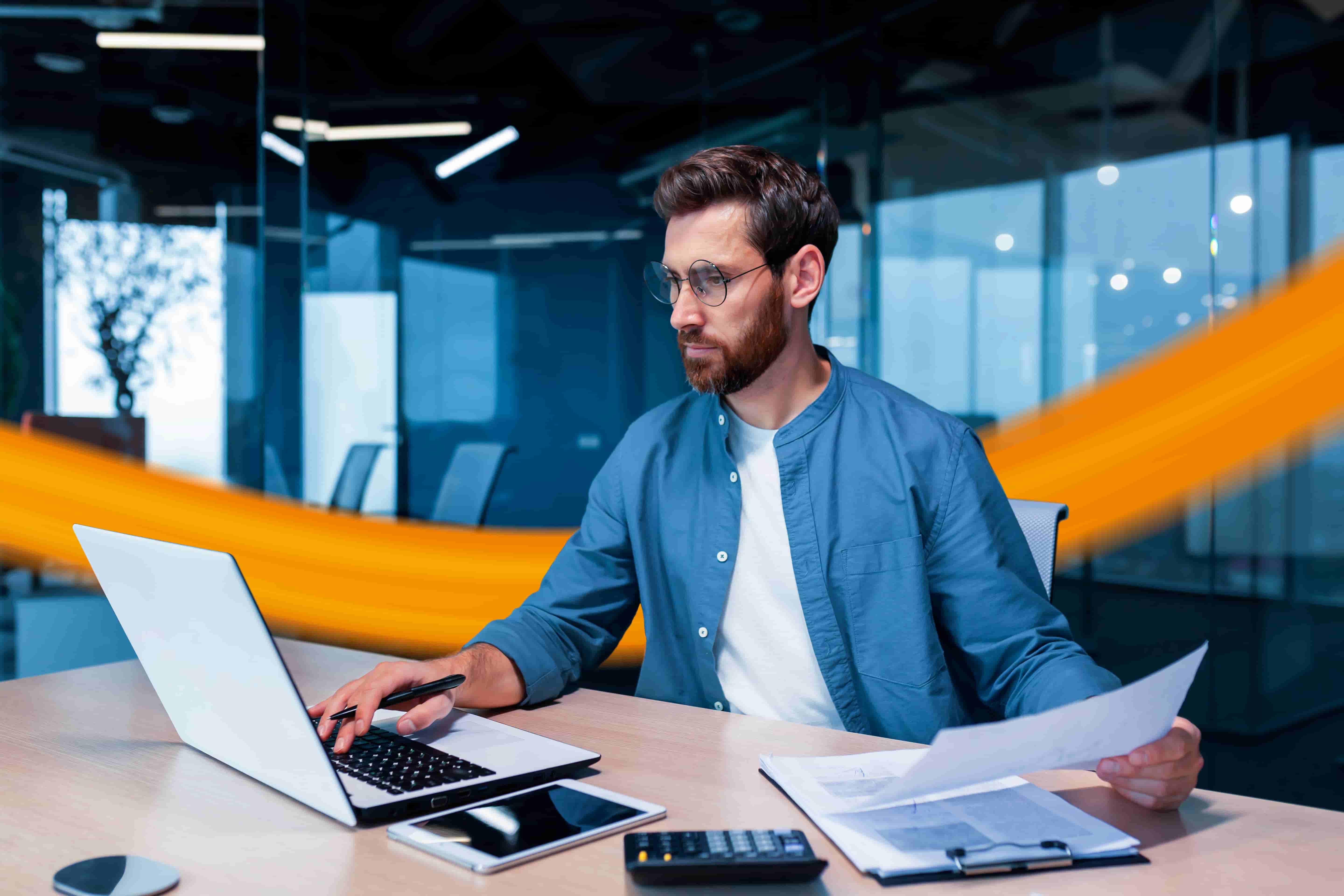 Mann im Office nutzt Laptop mit Fuhrparkmanagement Software