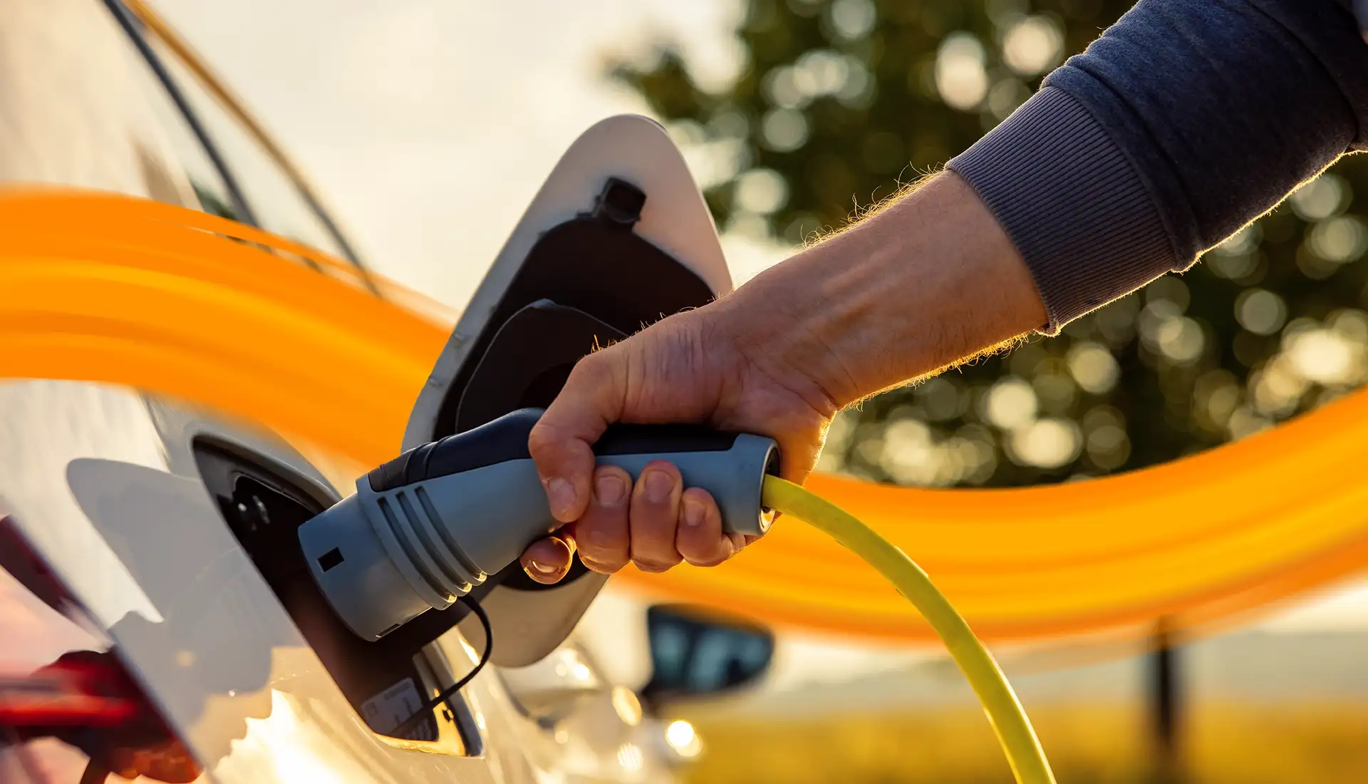 hand coming into the picture - you see an emobility car charging