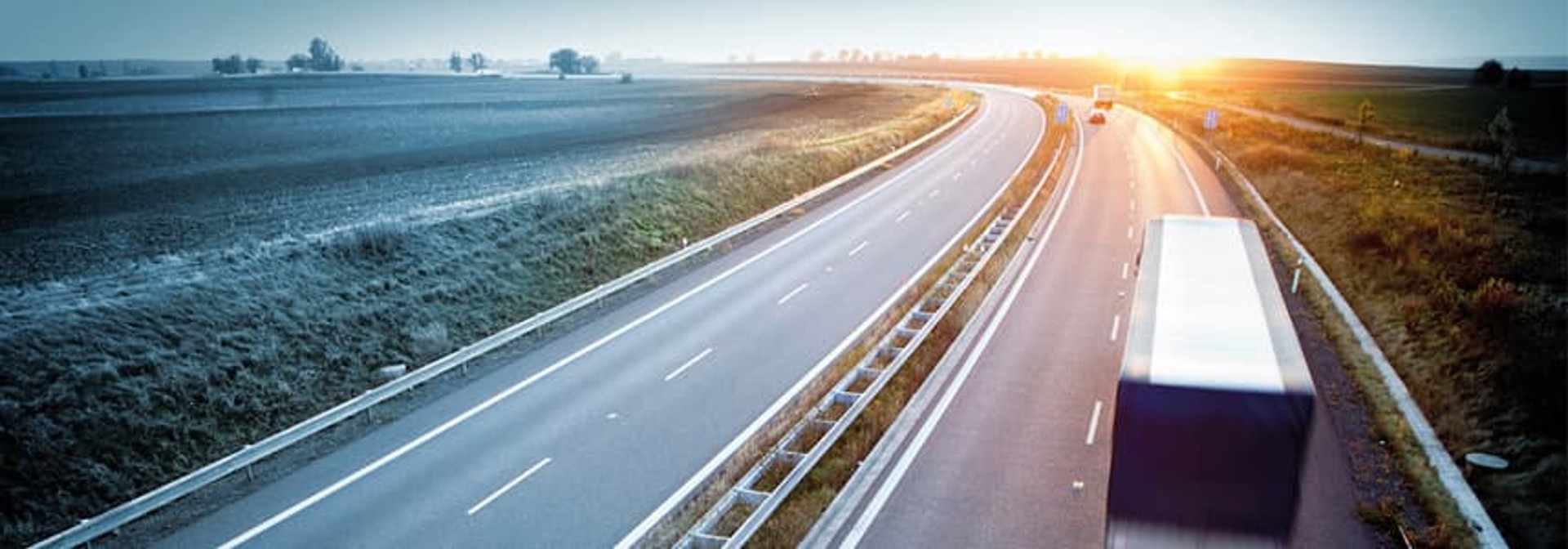 LKW fähr auf Autobahn in den Sonnenuntergang