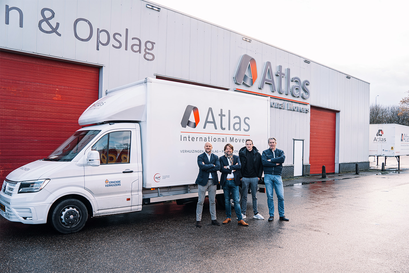 Employees of Atlas International Movers in front of a van