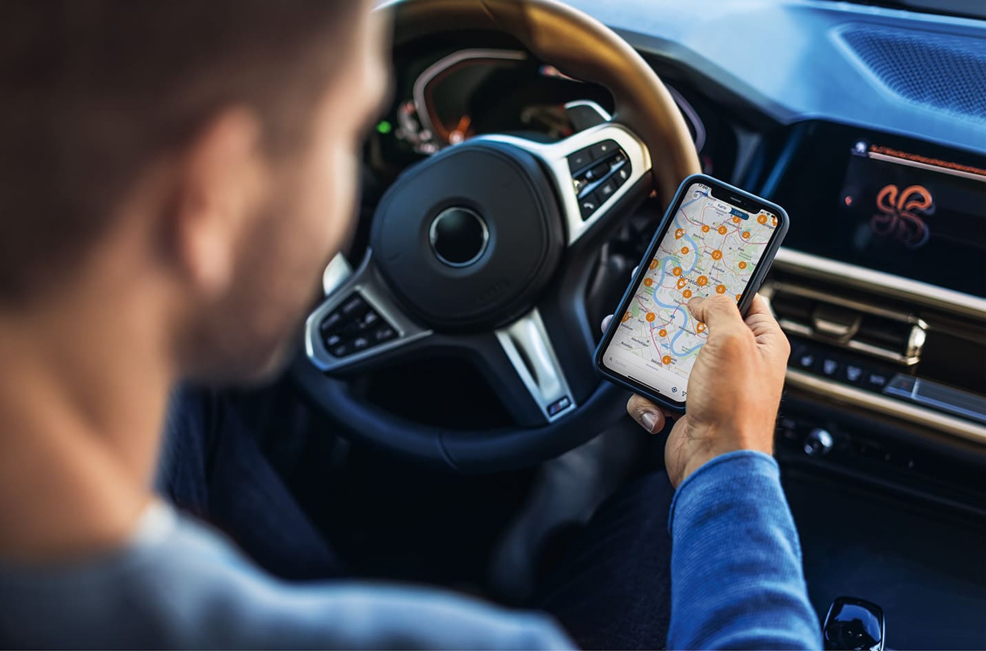 Man holds smartphone with DKV Mobility App in his hands Man holds smartphone with DKV Mobility App in his hands
