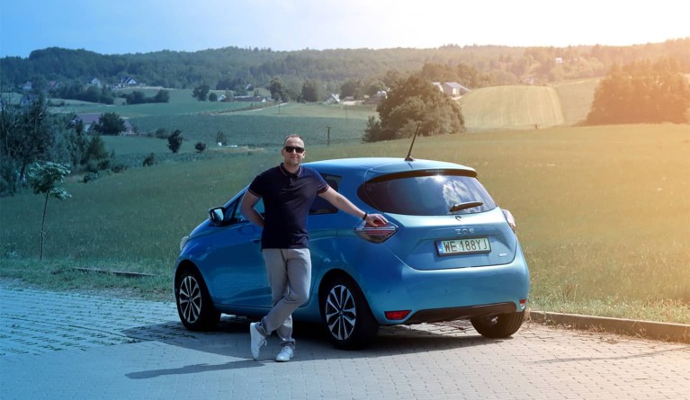 Dawid Polkowski stands in front of an electric car