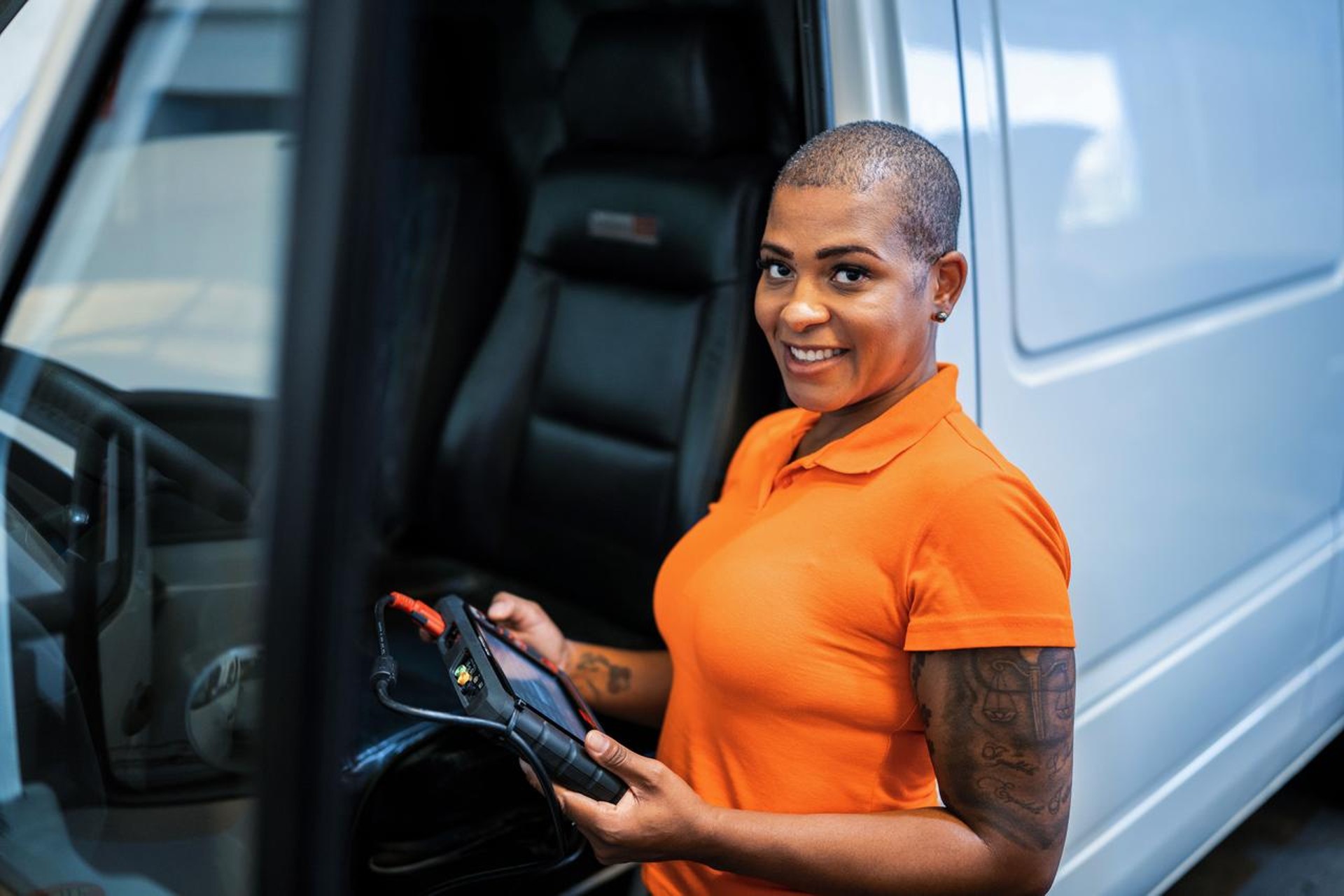 Woman with orange shirt next to a van