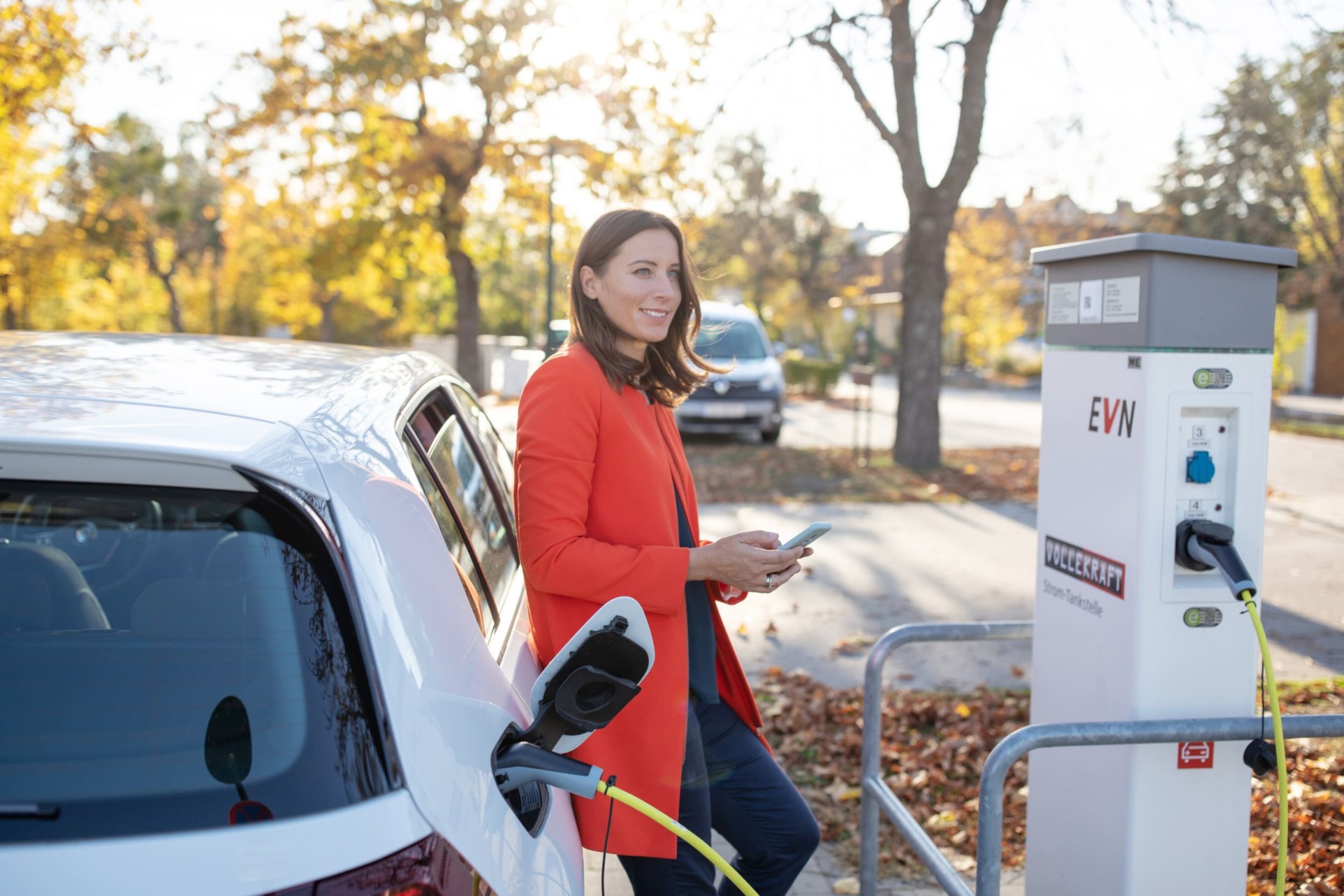 Dame läd auto draussen an Ladesäule