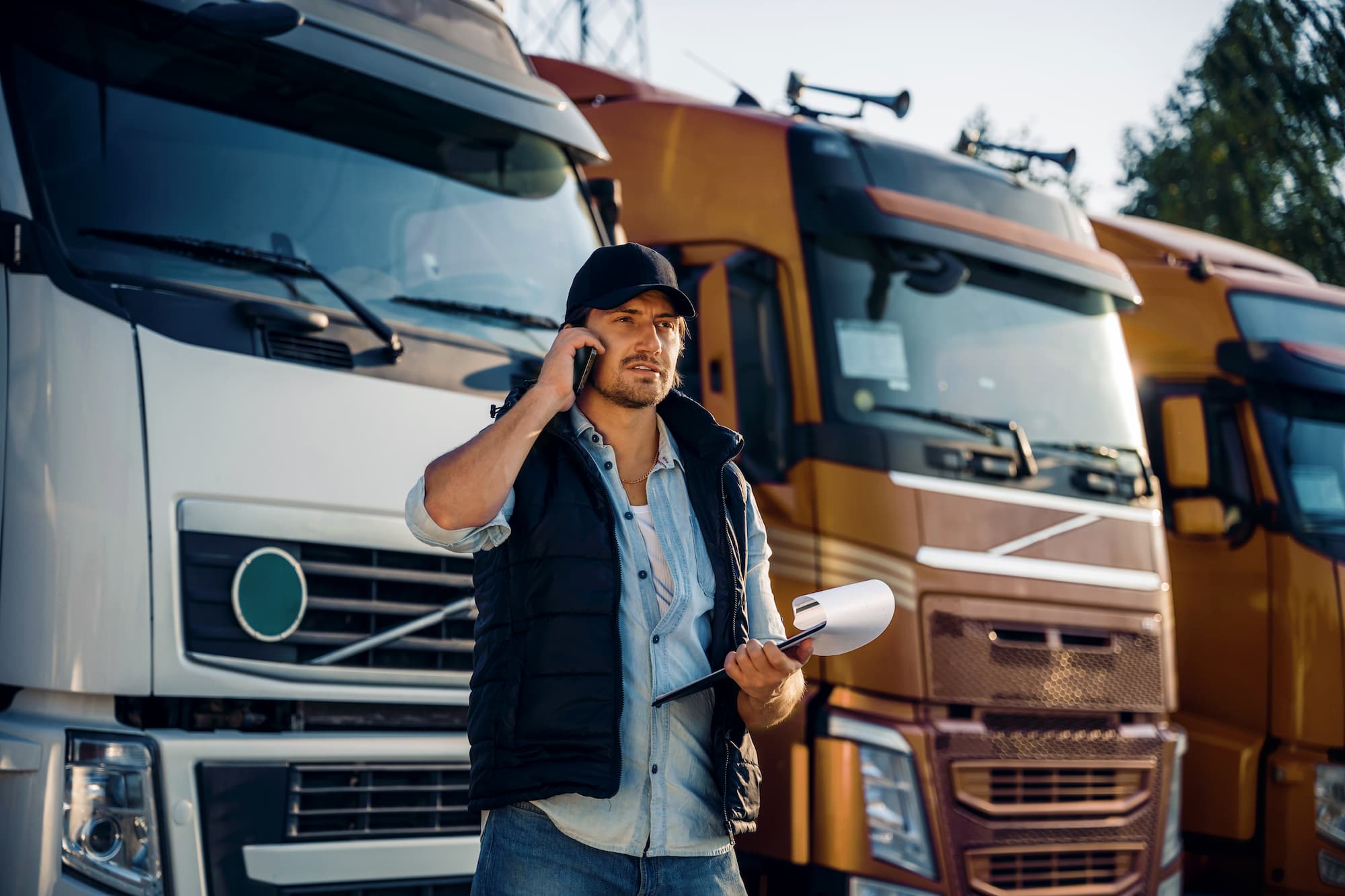 male fleet manager in front of trucks