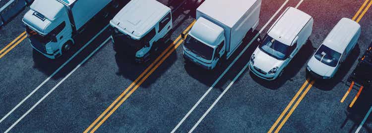 trucks and cars on highway with toll station