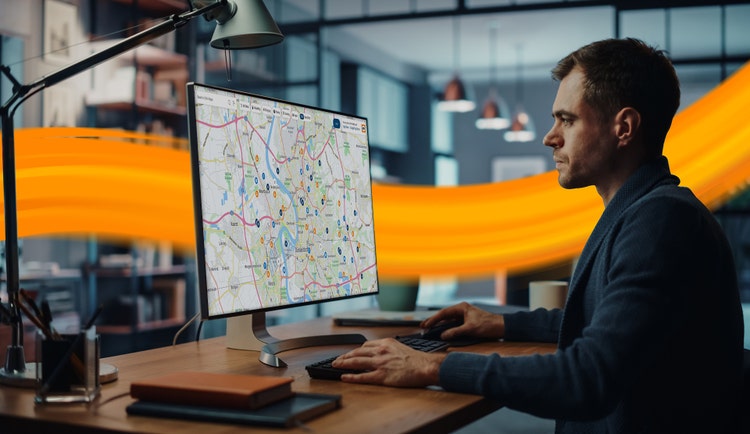 man in front of dektop with routeplanner on it