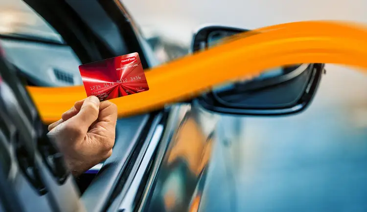 person holding DKV card out of the cars window