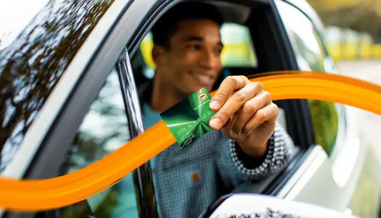Man in car holding DKV Card Climate fuel card