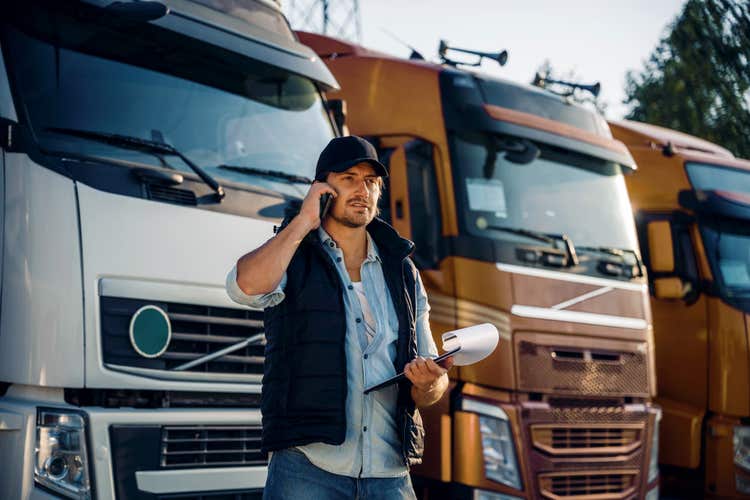 vyriškos lyties automobilių parko vadybininkas prie sunkvežimių