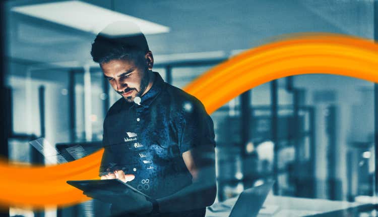 hand holding DKV card in front of a laptop