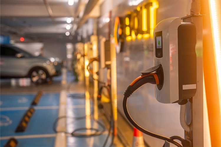 Electric car charging at a charging station in the underground parking garage